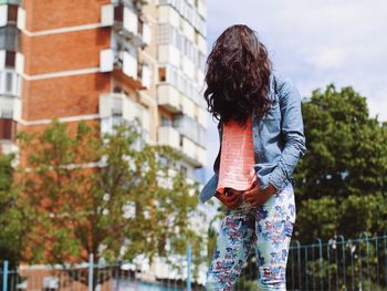 Woman standing against built structure