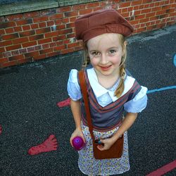 Portrait of smiling girl standing against brick wall