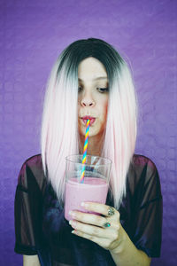 Portrait of a young woman drinking glass