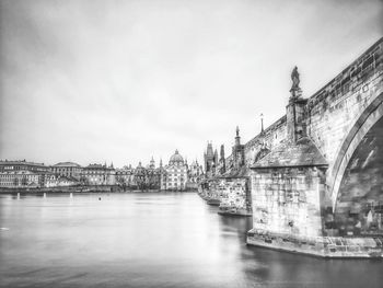 Bridge over river against buildings in city