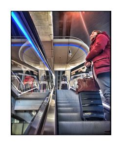Side view of woman standing on escalator