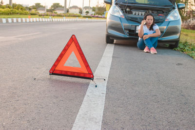 Woman sitting on road