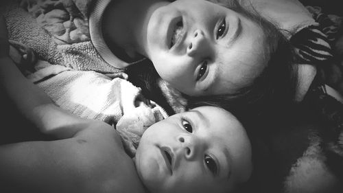 Portrait of cute siblings on bed