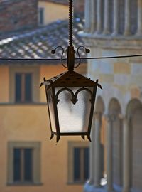 Low angle view of electric lamp against building