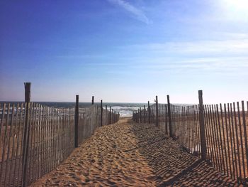 Railing at beach against sky