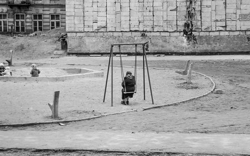 Man sitting on swing in playground