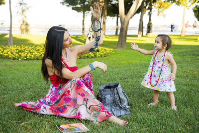 Happy mother and daughter in the park. beauty nature scene with family outdoor lifestyle.