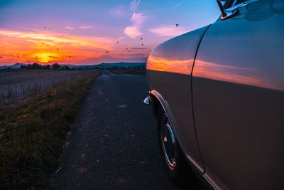 Close-up of car against sky during sunset