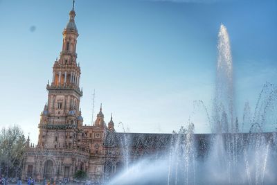 Fountain in city against sky