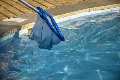 Cleaning pool from garbage with special net. concept of hygiene and healthy lifestyle.