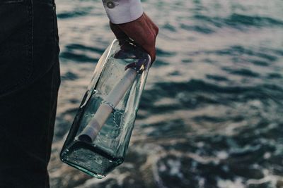 Low section of man holding water