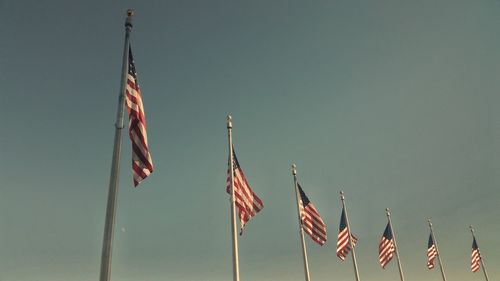 Low angle view of flags against clear sky