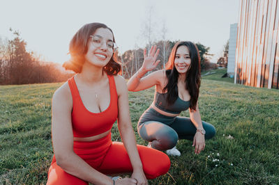 Portrait of young woman sitting on grassy field