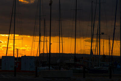 Silhouette sailboats against orange sky during sunset