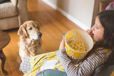 High angle view of girl eating popcorn while sitting at home