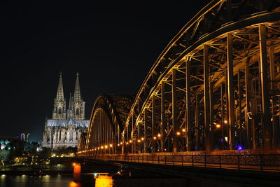 Illuminated bridge over river at night