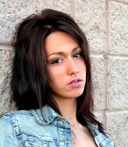 Portrait of beautiful young woman against wall