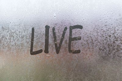 The word live written on the sweaty glass of the window