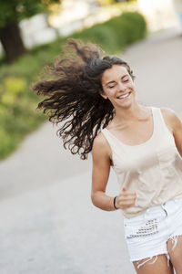 Beautiful young woman running in street