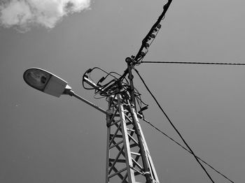 Low angle view of electricity pylon against sky