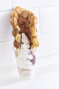 Close-up of gelato with ice cream in glass by wall