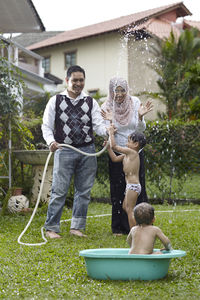 Full length of happy family playing in yard