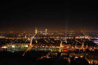 Illuminated city against sky at night