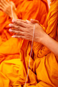 Close-up of man holding orange leaf