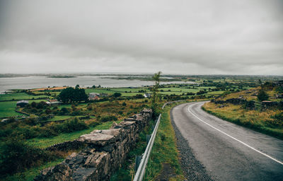 Panoramic shot of road amidst trees against sky