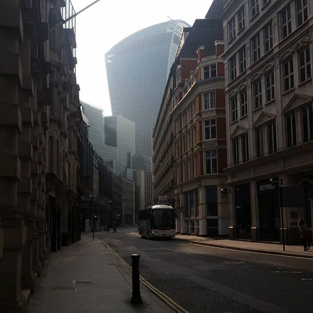 building exterior, architecture, built structure, city, transportation, the way forward, street, diminishing perspective, car, building, road, city street, land vehicle, incidental people, city life, mode of transport, vanishing point, sky, day, residential building