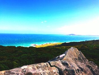 Scenic view of sea and mountains against clear blue sky