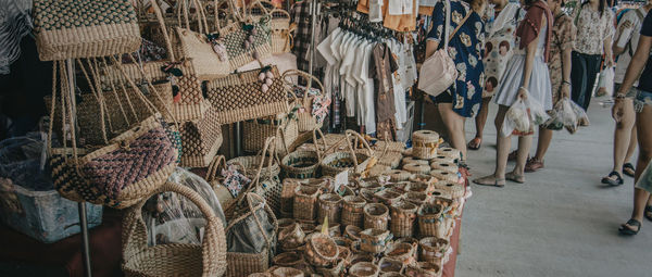 Low section of women standing by woven baskets and handbags at market