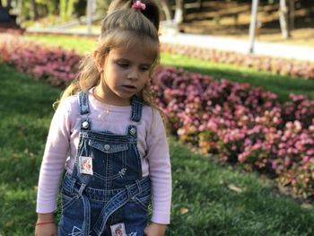 Full length of girl standing on purple flowering plants