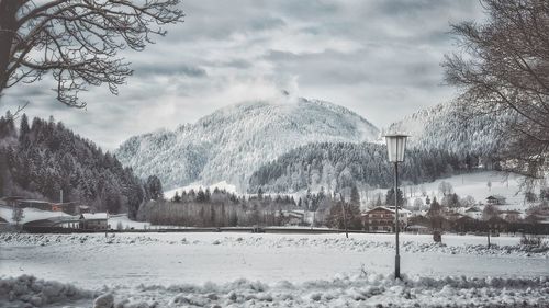 Ski lift over snowcapped mountains against sky