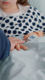 Midsection of woman lying on bed