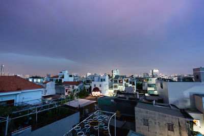 High angle view of illuminated buildings against blue sky