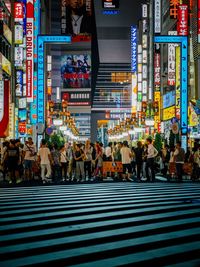 People walking on illuminated street at night