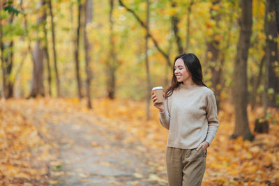 Woman standing in forest during autumn