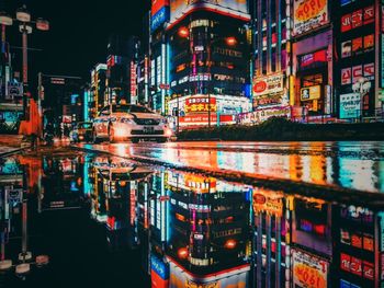 Illuminated buildings by street in city at night