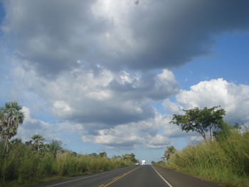 Road amidst trees against sky