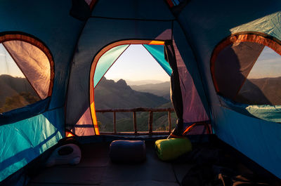 View from inside the tent looking out into nature morning forest and mountains.