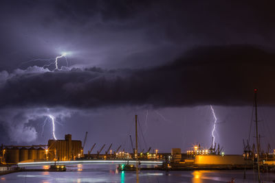 Panoramic view of lightning over sea against sky at night during the storm