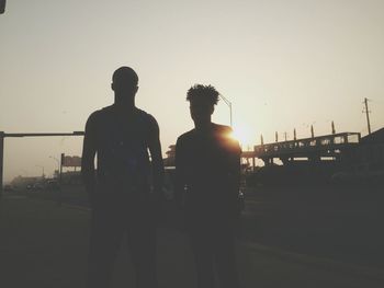 Silhouette people against clear sky during sunset