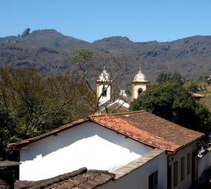 Houses by building against clear sky