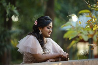 Side view of young woman sitting outdoors