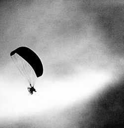 Low angle view of person paragliding against sky