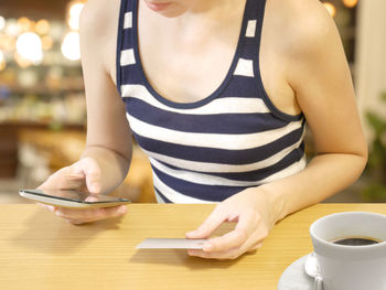 Midsection of woman using mobile phone