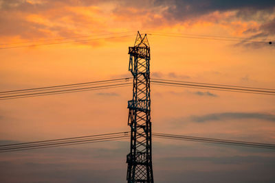 Low angle view of silhouette electricity pylon against romantic sky