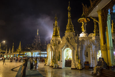 Group of people in temple outside building at night