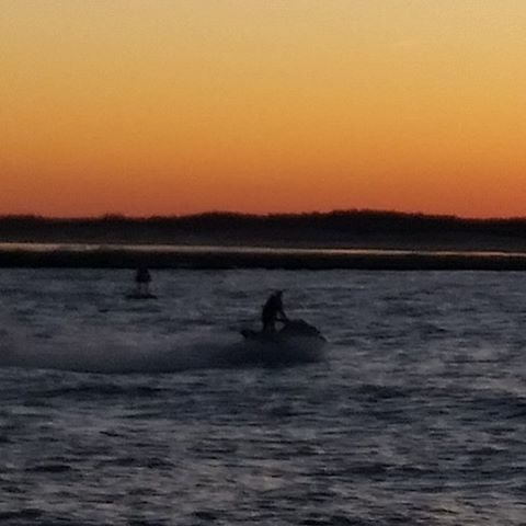 sunset, water, silhouette, waterfront, orange color, scenics, tranquil scene, beauty in nature, tranquility, clear sky, leisure activity, copy space, men, nature, sea, lifestyles, reflection, unrecognizable person, idyllic